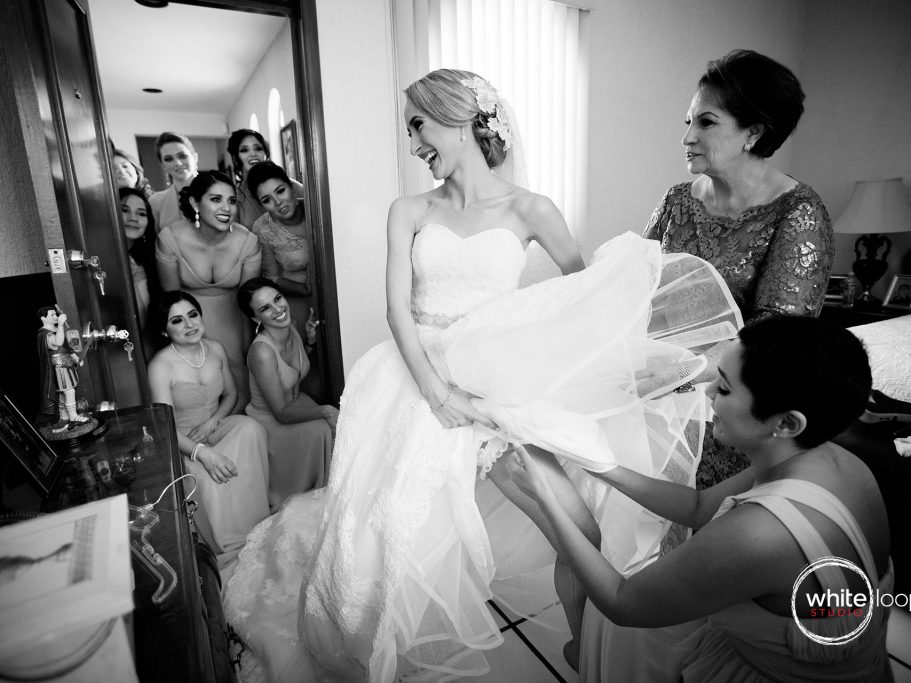 The close friends of the bride are adjusting and checking the final details of the dress.