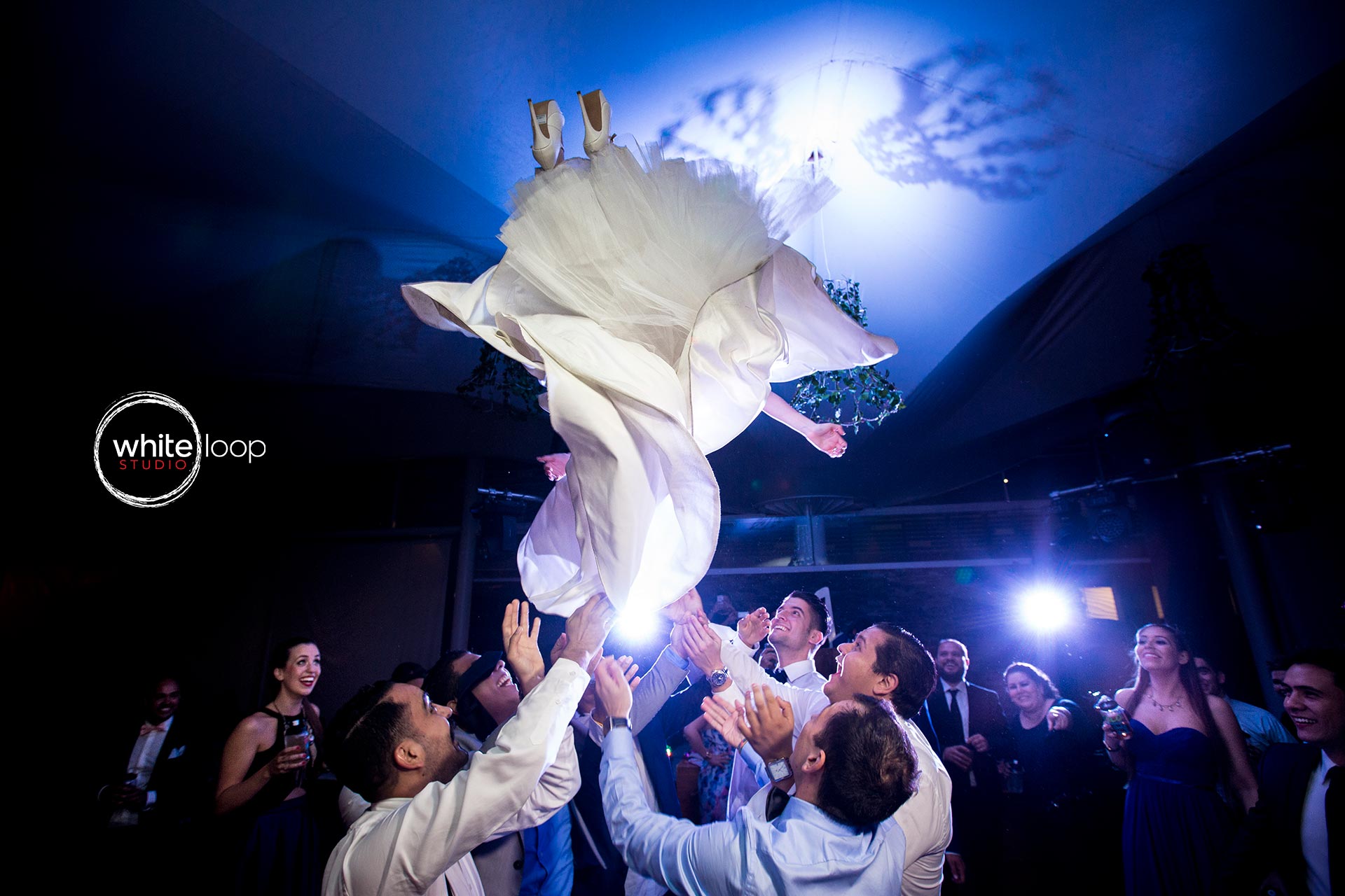 Some gentleman’s at the party launch the bride in the air, celebrating the engagement between her and the groom.