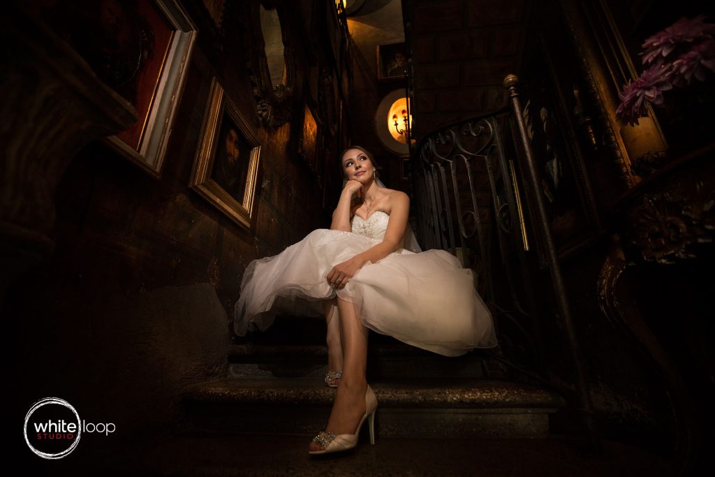 The bride is captured on the stairs, with poor light projecting the beauty of her in the wedding dress.